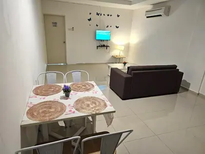 a living room with a table and chairs and a couch at Marina Island Apartment, Lumut in Lumut