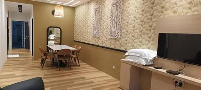 a living room with a table and a television at Adik Aisyah goldblack homestay cameron highlands in Tanah Rata
