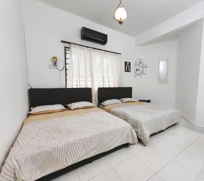 two beds in a white room with a window at 5 min to ipoh town pasir puteh 5br 22pax in Ipoh