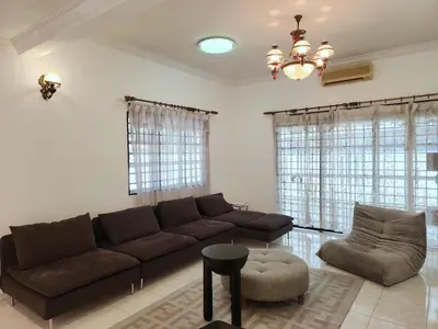a living room with a brown couch and a chair at 5 min to ipoh town pasir puteh 5br 22pax in Ipoh