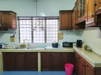 a kitchen with wooden cabinets and a sink and a window at 5 min to ipoh town pasir puteh 5br 22pax in Ipoh