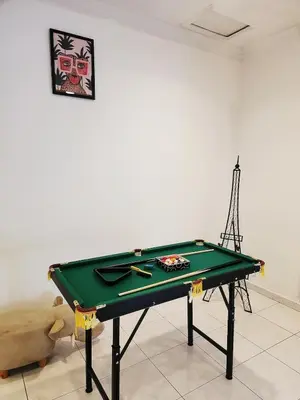 a green ping pong table in a room with a cue at 5 min to ipoh town pasir puteh 5br 22pax in Ipoh