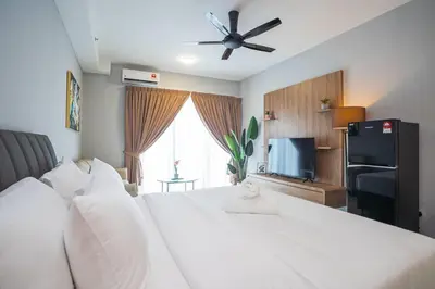 a bedroom with a large white bed with a ceiling fan at Wyndham Garden Suites IPOH ICC in Ipoh