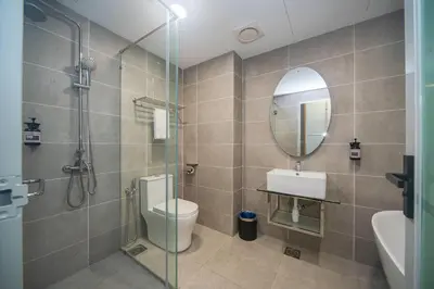 a bathroom with a shower and a toilet and a mirror at Wyndham Garden Suites IPOH ICC in Ipoh