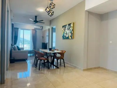a dining room and living room with a table and chairs at Wyndham Garden Suites IPOH ICC in Ipoh