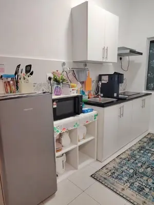 a kitchen with white cabinets and a microwave at AzzSpacesAnderson in Ipoh