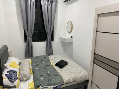 a small bedroom with a bed and a window at Rania Homestay Tasek Gelugor in Padang Chempedak