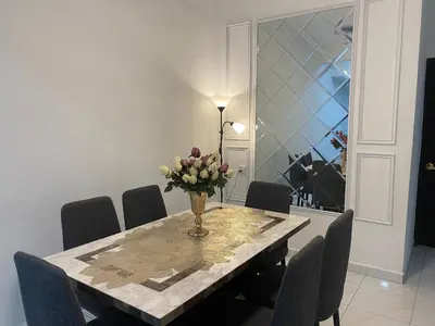 a dining room table with a vase of flowers on it at Rania Homestay Tasek Gelugor in Padang Chempedak