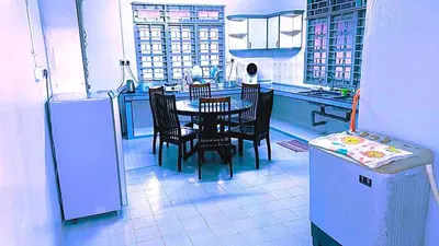 a kitchen with a table and chairs and a refrigerator at D' Gerik Homestay Taman Sinaran in Gerik