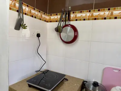 a laptop on a counter in a kitchen with utensils at Cozy Stay ALMA NearAEON\u5927\u5c71\u811a\u6e29\u99a8\u6c11\u5bbf in Bukit Mertajam