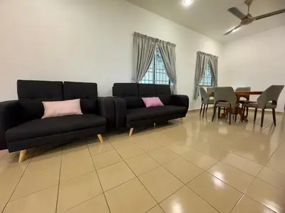 a living room with a black couch and a table at Cozy Stay ALMA NearAEON\u5927\u5c71\u811a\u6e29\u99a8\u6c11\u5bbf in Bukit Mertajam