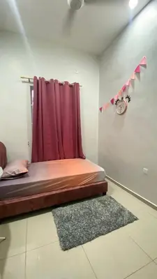 a bed in a room with a red curtain at D Cahaya Homestay in Tapah
