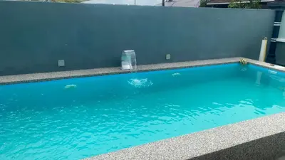 a large blue swimming pool next to a wall at D Cahaya Homestay in Tapah