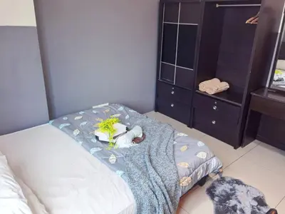 a bedroom with a bed with a blue blanket and a dresser at Kinta Riverfront Apartment Ipoh, Fully Air-Con Suite IPOH in Ipoh