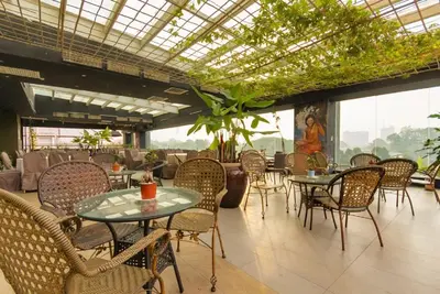 a dining room with tables and chairs and plants at Kinta Riverfront Apartment Ipoh, Fully Air-Con Suite IPOH in Ipoh