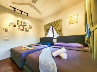 two beds in a room with purple beds at Ipoh 168 Taman Pelangi, Persiaran Halaman Ampang Ipoh Homestay in Ipoh