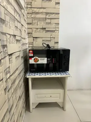 a microwave sitting on a table next to a wall at AYAAN BLOSSOM BUDGET HOMESTAY FREE WiFi and Netflix in Tanah Rata