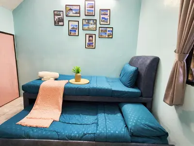 a room with a blue couch and a table at IPOH Taman Pelangi Double Storey Homestay in Ipoh