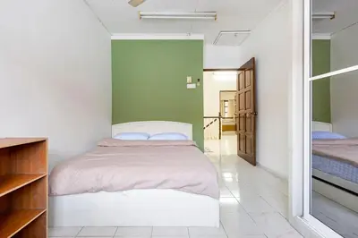 a bedroom with two beds and a green wall at Riverview Staycation 5mins to Sunway Carnival for 9 pax in Perai