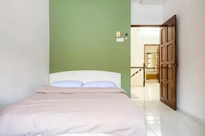 a bedroom with a white bed and a green wall at Riverview Staycation 5mins to Sunway Carnival for 9 pax in Perai