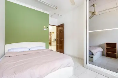 a bedroom with a white bed and a green wall at Riverview Staycation 5mins to Sunway Carnival for 9 pax in Perai