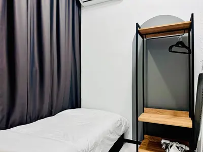 a small bedroom with a bed and a mirror at 3BR apartments 10pax george town netflix in Jelutong