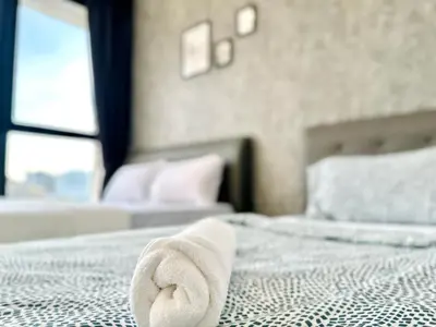 a towel laying on a bed in a bedroom at 3BR urban suites 8-10pax luxury family stay netflix in Jelutong