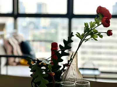 a table with two vases with flowers in a window at 3BR urban suites 8-10pax luxury family stay netflix in Jelutong