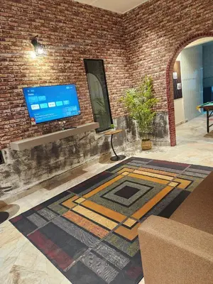 a living room with a tv on a brick wall at Sun Rock Home by Ipoh Maju Stay in Ipoh