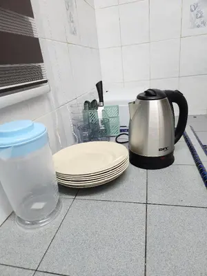 a tea kettle and plates and a pitcher of water on a counter at Sun Rock Home by Ipoh Maju Stay in Ipoh