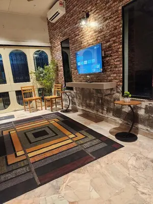 a living room with a tv on a brick wall at Sun Rock Home by Ipoh Maju Stay in Ipoh
