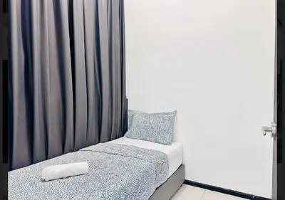 a small bed in a room with a curtain at relax family stay 3BR 10pax urban in Jelutong