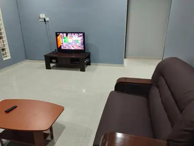 a living room with a couch and a tv at DeStay Taiping in Taiping