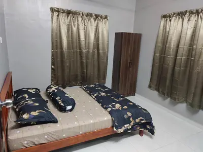a bedroom with a bed with pillows and curtains at DeStay Taiping in Taiping