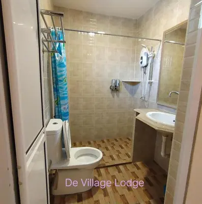 a bathroom with a toilet and a sink at De Village Lodge in Balik Pulau