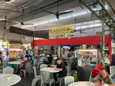 a group of people sitting at tables in a restaurant at De Village Lodge in Balik Pulau