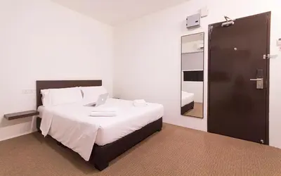a bedroom with a bed with a laptop on it at HOTEL RAUB since 1968 in Raub