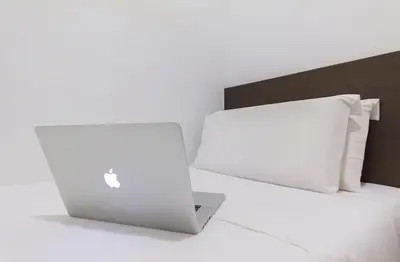 two laptop computers sitting on top of a bed at HOTEL RAUB since 1968 in Raub