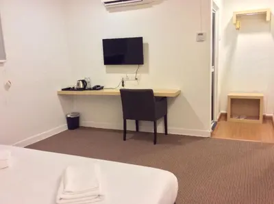 a room with a desk with a monitor and a chair at HOTEL RAUB since 1968 in Raub