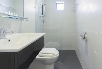 a white bathroom with a sink and a toilet at HOTEL RAUB since 1968 in Raub