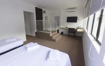 a hotel room with a bed and a desk with a television at HOTEL RAUB since 1968 in Raub
