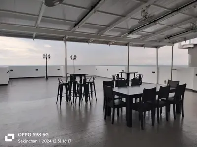 a dining room with a table and chairs and the ocean at Sekinchan SeaView Garden 20pax 6R6B HighView in Sekincan