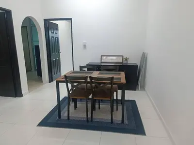 a dining room table with two chairs and a piano at Jwa Vacastay in Lumut
