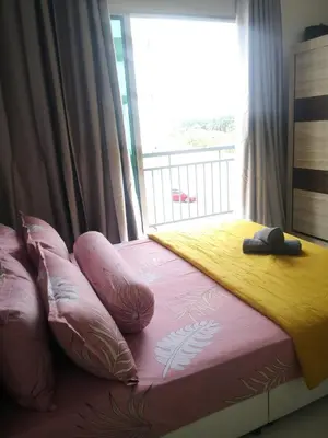 a bedroom with a bed with pillows and a window at Jwa Vacastay in Lumut