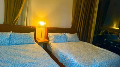 a bedroom with two beds and a lamp on a table at Premium 5 queen bed luxury 2BR suites infinity pool netlfix in Jelutong