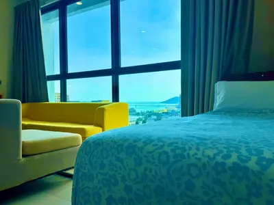 a bedroom with a bed and a couch and a large window at Premium 5 queen bed luxury 2BR suites infinity pool netlfix in Jelutong