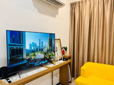 a living room with a large television on a desk at Premium 5 queen bed luxury 2BR suites infinity pool netlfix in Jelutong