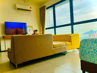 a living room with a couch and a tv at Premium 5 queen bed luxury 2BR suites infinity pool netlfix in Jelutong