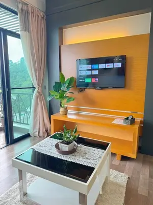 a living room with a tv and a coffee table at Sunrise & KeaFarmview at Hilltop NOVA CoolSummer in Tanah Rata