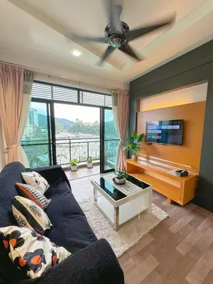 a living room with a blue couch and a tv at Sunrise & KeaFarmview at Hilltop NOVA CoolSummer in Tanah Rata